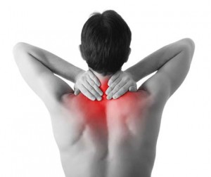 Rear view of a young man holding her neck in pain, isolated on white background, monochrome photo with red as a symbol for the hardening